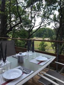 a white table with plates and utensils on a balcony at Eleni appart 4p à Richelieu in Chaveignes +7 photos