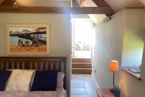 a bedroom with a bed and a table with a lamp at Little Old Barn at Manor Farmhouse in West Chinnock