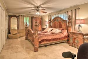 ein Schlafzimmer mit einem großen Holzbett und einem Sofa in der Unterkunft Luxe Hot Springs Home By Oaklawn Racing Casino in Hot Springs
