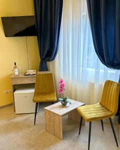 two chairs and a table in front of a window at Hotel Pin Azuga in Azuga