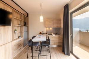 una cucina con tavolo, sedie e TV di Evo Suites Apartments a Limone sul Garda