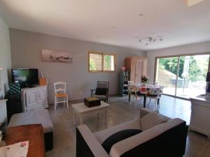 a living room with a couch and a tv and a table at Magnifique maison avec vue panoramique in Carlux