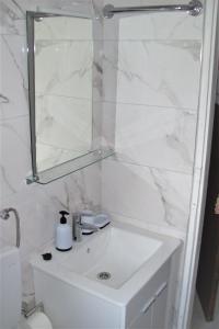a white bathroom with a sink and a mirror at Dinka's Apartment in Stari Grad
