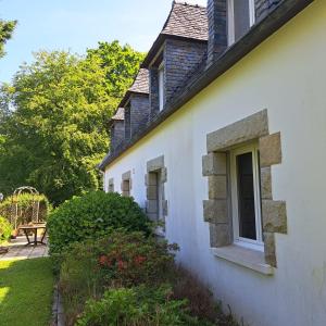 Una casa blanca con una ventana en el costado. en L'échappée, Chambres et Tables d'hôtes en Saint-Fiacre