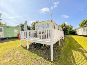 a large white house sitting on top of a yard at 6 Berth Caravan Nearby Great Yarmouth In Norfolk Ref 10022rp in Belton