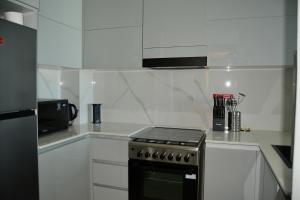 een witte keuken met een fornuis en een magnetron bij Luxurious Smart Home in Dubai