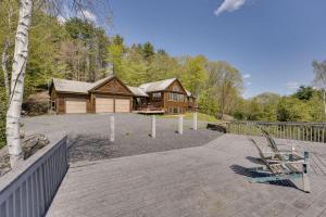 een blokhut in het bos naast een houten terras bij Luxury Vermont Vacation Rental Private Hot Tub! in Brownsville