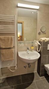 ein Bad mit einem Waschbecken und einem Spiegel in der Unterkunft Haus Marchegg in Tux