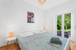 a white bedroom with a large bed and a window at Apartments Villa Verde in Novigrad Istria