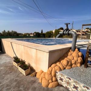 a water fountain on top of a swimming pool at Casa Amor - Casa Esmeralda - 3 Bedroom Apartment with Shared Pool & Jacuzzi Close to Parque Regional Sierra del Carche, hiking trails & striking views in Raspay