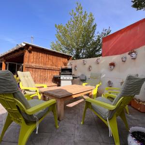 un patio con mesa de madera, sillas y parrilla en Casa Amor - Casa Esmeralda - 3 Bedroom Apartment with Shared Pool & Jacuzzi Close to Parque Regional Sierra del Carche, hiking trails & striking views, en Raspay