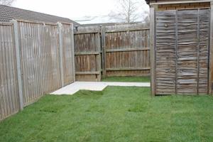 a backyard with a wooden fence and grass at Grebe Court by MT Property in Cambridge