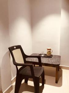 Una silla negra y una mesa con una taza. en Prestige Guest House & Hostel, en Bilāspur