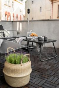 a table and chairs on a patio with a basket of flowers at Central Apartamenty in Jelenia Góra