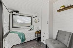a bedroom with a bed and a chair and a window at New Wilderness Hideout-Cozy Container Home in Fredericksburg