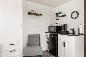 eine Küche mit einem schwarzen Kühlschrank und einem Stuhl in der Unterkunft New Wilderness Hideout-Cozy Container Home in Fredericksburg