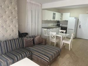 ハニオティスにあるPalms Luxury Greek Villas 1のリビングルーム(ソファ、テーブル付)、キッチンが備わります。