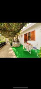 uma casa com um pátio verde com uma mesa e cadeiras em Guesthouse Coralba em Ischia