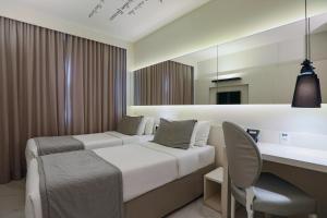 リオデジャネイロにあるNobile Hotel Copacabana Designのベッドとデスクが備わるホテルルームです。