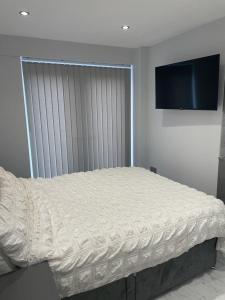 a bed in a bedroom with a television on the wall at Cosway in Calverton