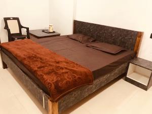 a large bed in a room with a chair at Prestige Guest House & Hostel in Bilāspur