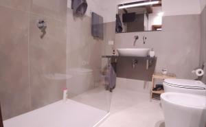 a bathroom with a shower and a toilet and a sink at Civico in Gubbio +23 photos