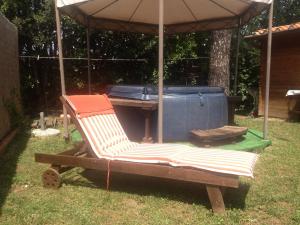 a chair sitting under an umbrella next to a hot tub at B&B Casa Gori in Greve in Chianti
