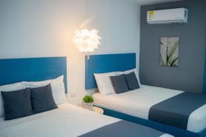 2 camas en un dormitorio con azul y blanco en Hotel ADAZ Mediterráneo, en Santa Marta