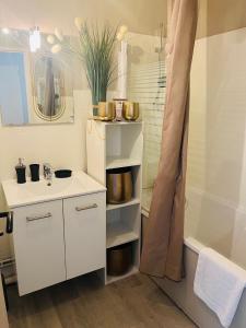 ein weißes Bad mit einem Waschbecken und einer Dusche in der Unterkunft Sur le sable 2 3 pers WIFI in Boulogne-sur-Mer
