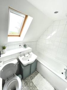 a white bathroom with a toilet and a sink at Luxurious 2 bed in Beaulieu Park in Broomfield