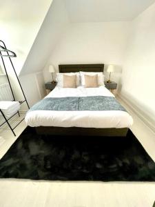 een slaapkamer met een groot bed en een zwart tapijt bij Luxurious 2 bed in Beaulieu Park in Broomfield