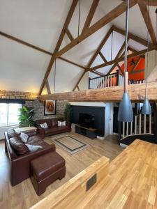ein Wohnzimmer mit einem Sofa und einem Tisch in der Unterkunft Stylish central 6 bedroom converted Granary in Stamford