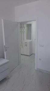 a white bathroom with white cabinets and a mirror at Ohrid-Struga Ezerski Lozja in Struga