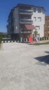 a large building with a playground in front of it at Ohrid-Struga Ezerski Lozja in Struga