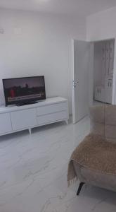 a living room with a flat screen tv on a white cabinet at Ohrid-Struga Ezerski Lozja in Struga