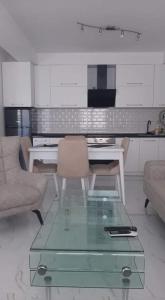 a living room with a table and chairs and a kitchen at Ohrid-Struga Ezerski Lozja in Struga