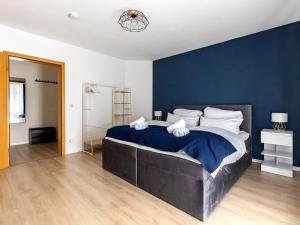 1 dormitorio con 1 cama grande y pared azul en MICOA: Tiefgarage/Netflix/Highspeed Arbeitsplatz en Gelsenkirchen