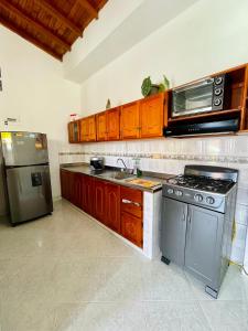 Apartamento de Descanso - Doradal في Doradal: مطبخ مع موقد ومغسلة وميكروويف