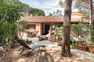a patio with a table and a chair in front of a house at RESIDENZE Coda Cavallo - Le Farfalle in Capo Coda Cavallo