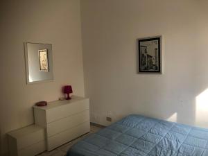 een slaapkamer met een bed en een dressoir bij Casa Icaro in Marinella di Selinunte