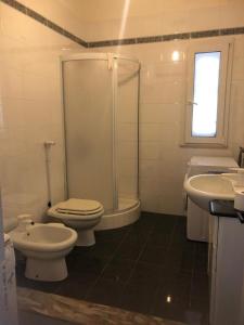 een badkamer met 2 toiletten, een douche en een wastafel bij Casa Icaro in Marinella di Selinunte