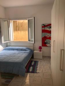 een slaapkamer met een bed en een raam bij Casa Icaro in Marinella di Selinunte