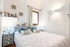 a bedroom with a bed with blue pillows and a window at RESIDENZE Coda Cavallo - Le Farfalle in Capo Coda Cavallo +36 photos