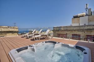 a hot tub on the roof of a building at Valletta Luxe 3-Bedroom Duplex Penthouse with Sea View Terrace and Jacuzzi in Valletta