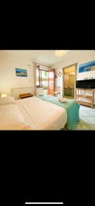 Guesthouse Coralba في ايسكيا: غرفة نوم بسريرين وتلفزيون فيها