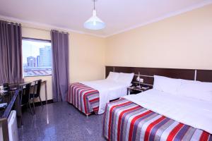 Una habitación de hotel con dos camas y una ventana. en Da Vinci Hotel & Conventions by Easy Hotéis, en Manaus