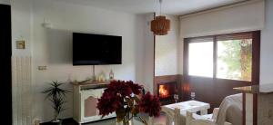 a living room with a fireplace and a tv at La Casita del Arroyo in Arroyo Frio