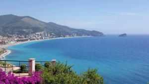 uma vista para uma praia com flores roxas em [300 metri dal mare] Relax con aria condizionata em Spotorno