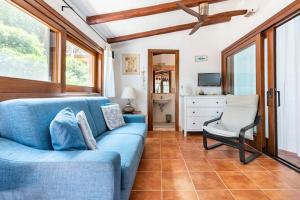 sala de estar con sofá azul y silla en RESIDENZE Coda Cavallo - Le Farfalle, en Capo Coda Cavallo