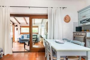 a kitchen and dining room with a white table and chairs at RESIDENZE Coda Cavallo - Le Farfalle in Capo Coda Cavallo
